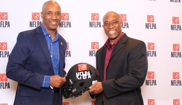 image of 2 guys posing for a photo at the nfl players association corporate event