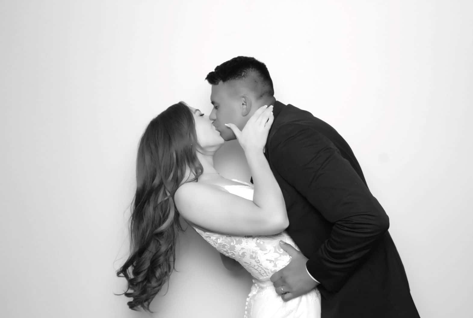 image of newly married couple kissing in the photo booth