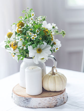 image of a vase of flowers with mini pumpkin and candle