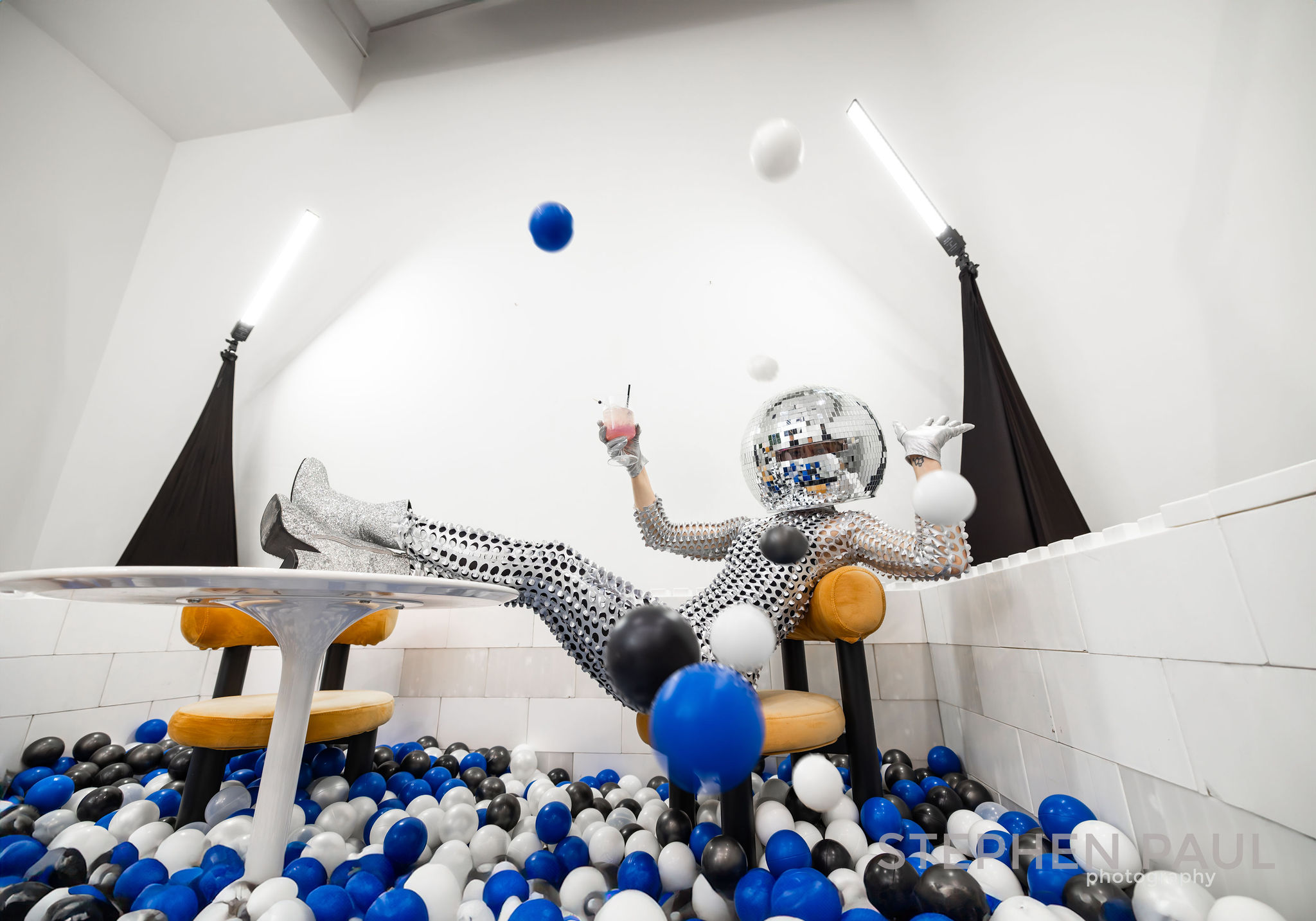 image of a disco head person sitting in a ball pit